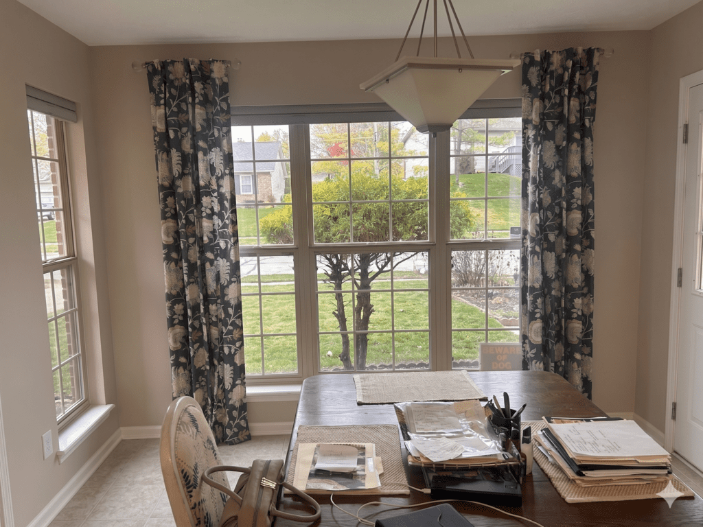 InStyle Blinds IN - a dining room has a large window with custom drapery panels.  