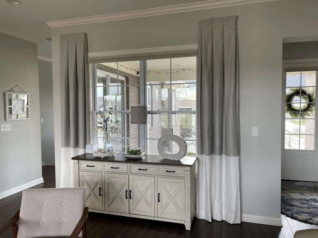 InStyle Blinds IN - an elegant entryway has custom drapery panels on the front window. 